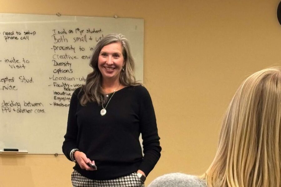 woman smiling at people in front of a whiteboard