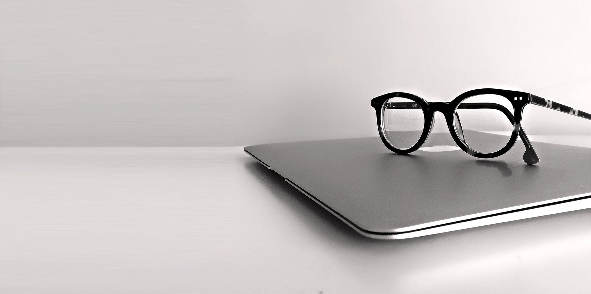 Laptop with reading glasses on top
