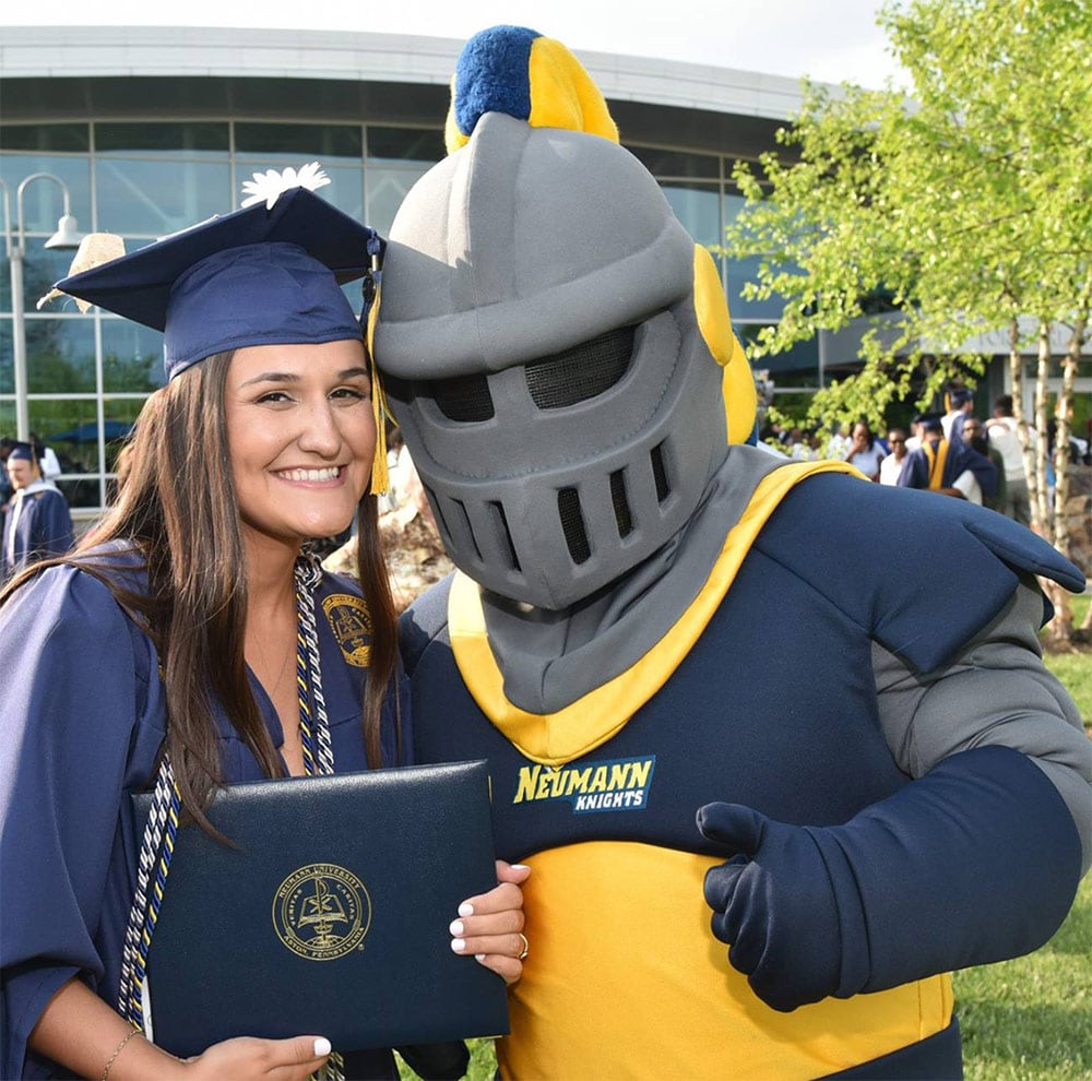 Neumann University graduate with mascot