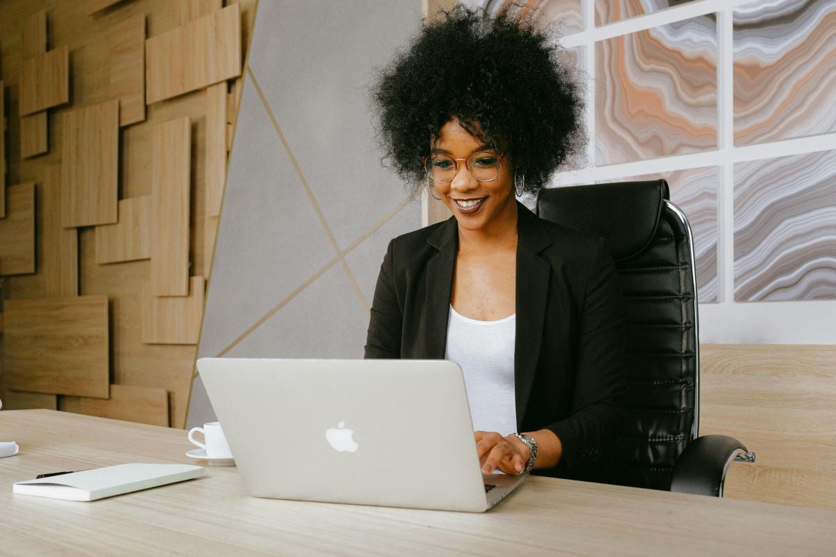 a person sitting at a desk using a laptop